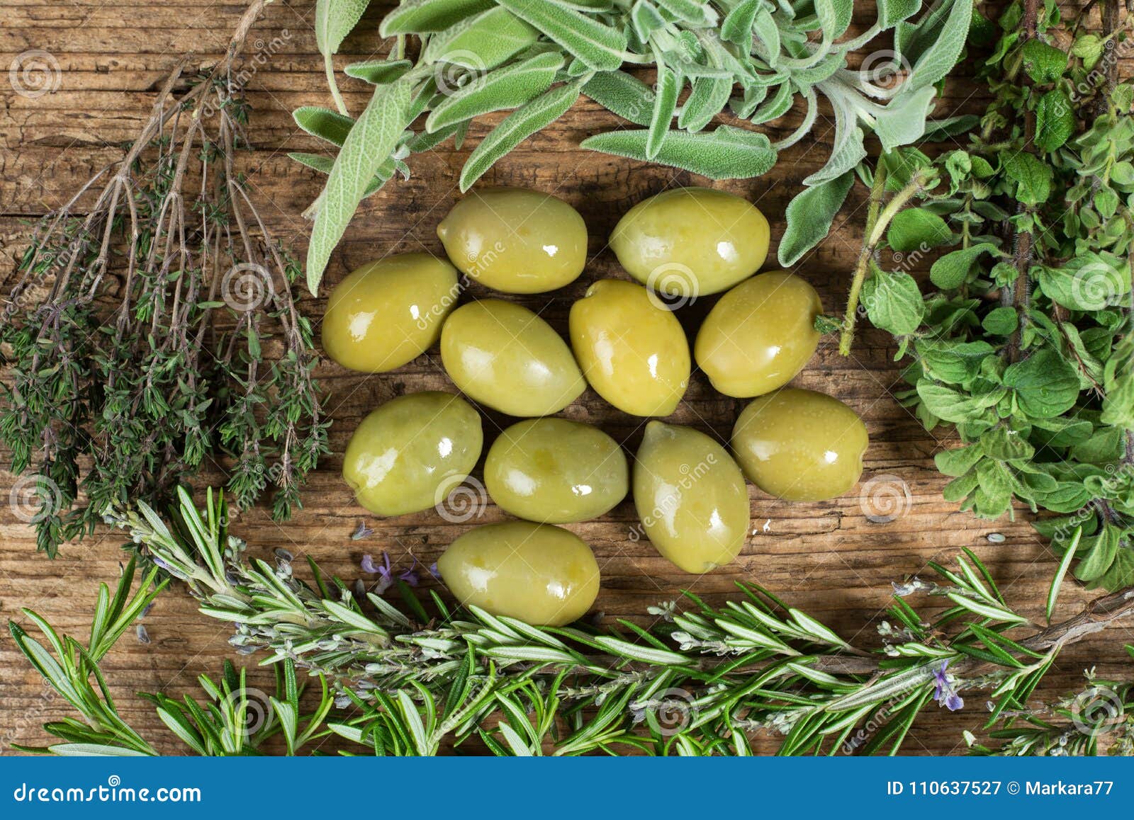 Green Olives with Several Herbs Around on Wooden Table. Stock Image