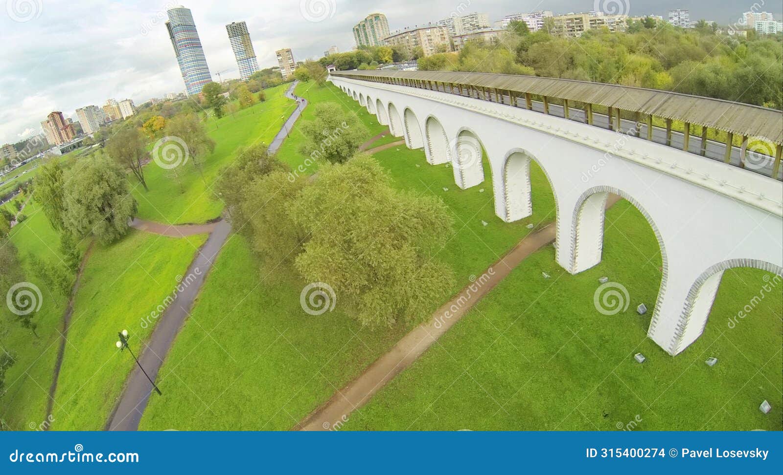 green park with aqueduct in city. view from