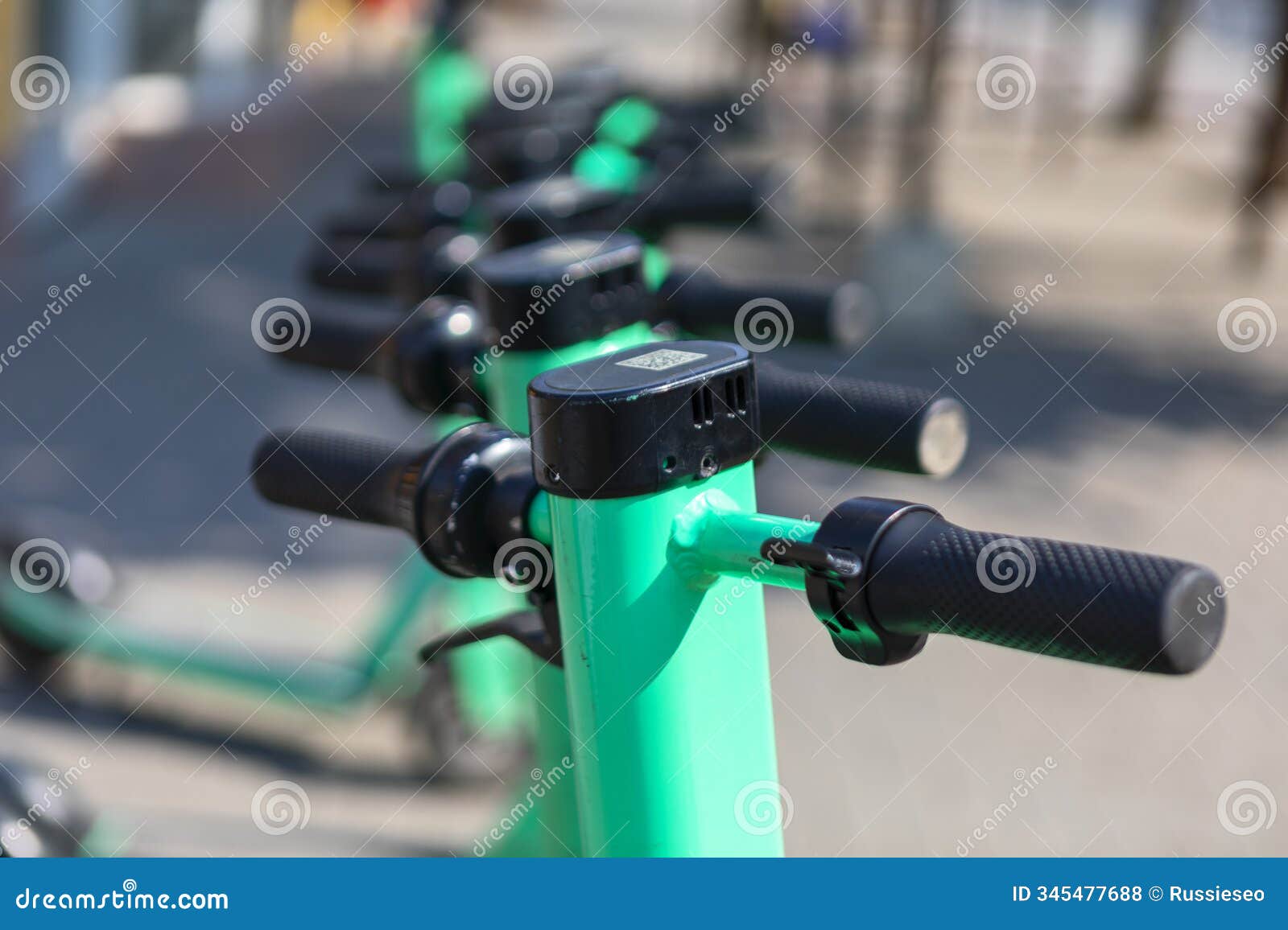 green scooters parked neatly along the sidewalk