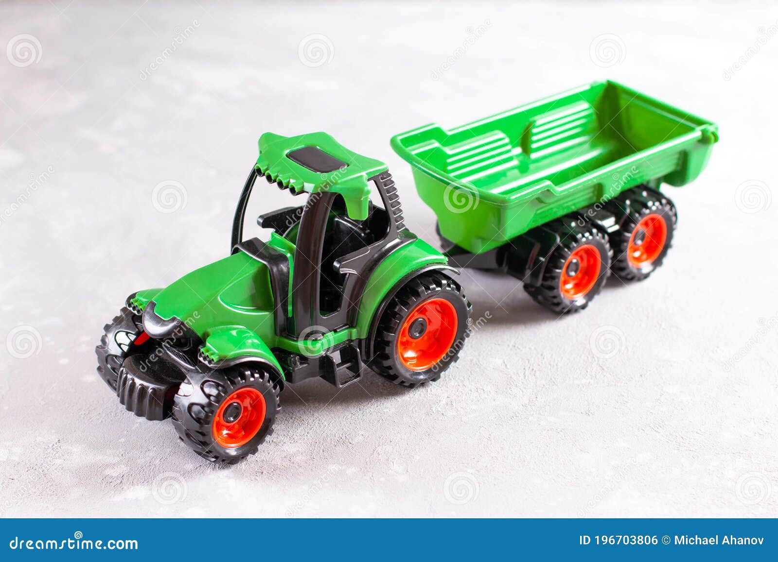 A Green Tractor. Toy for Children. Toy Tractor with the Trailer on