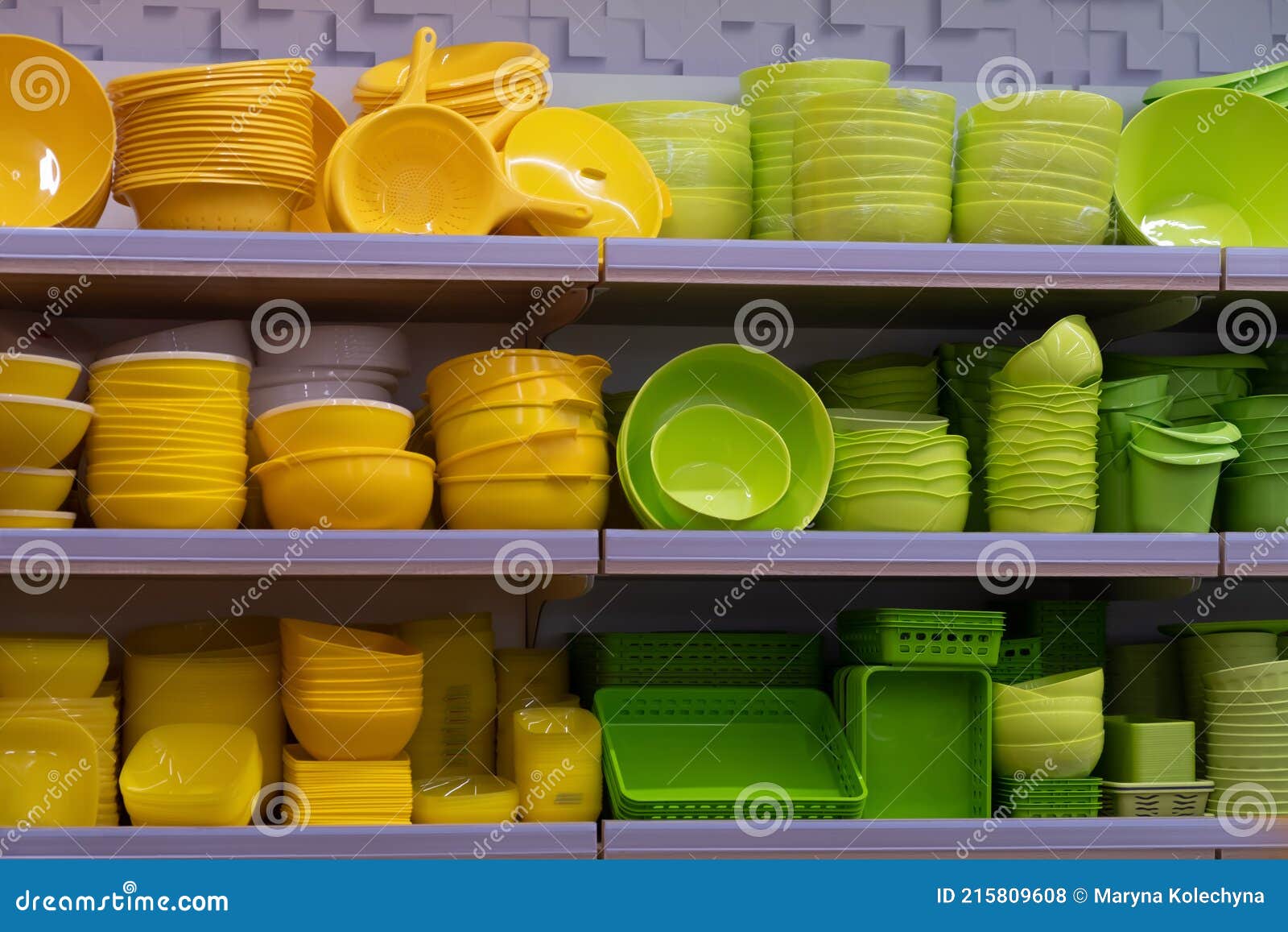 Green and Yellow Plastic Saucers and Plates on Store Shelves Stock