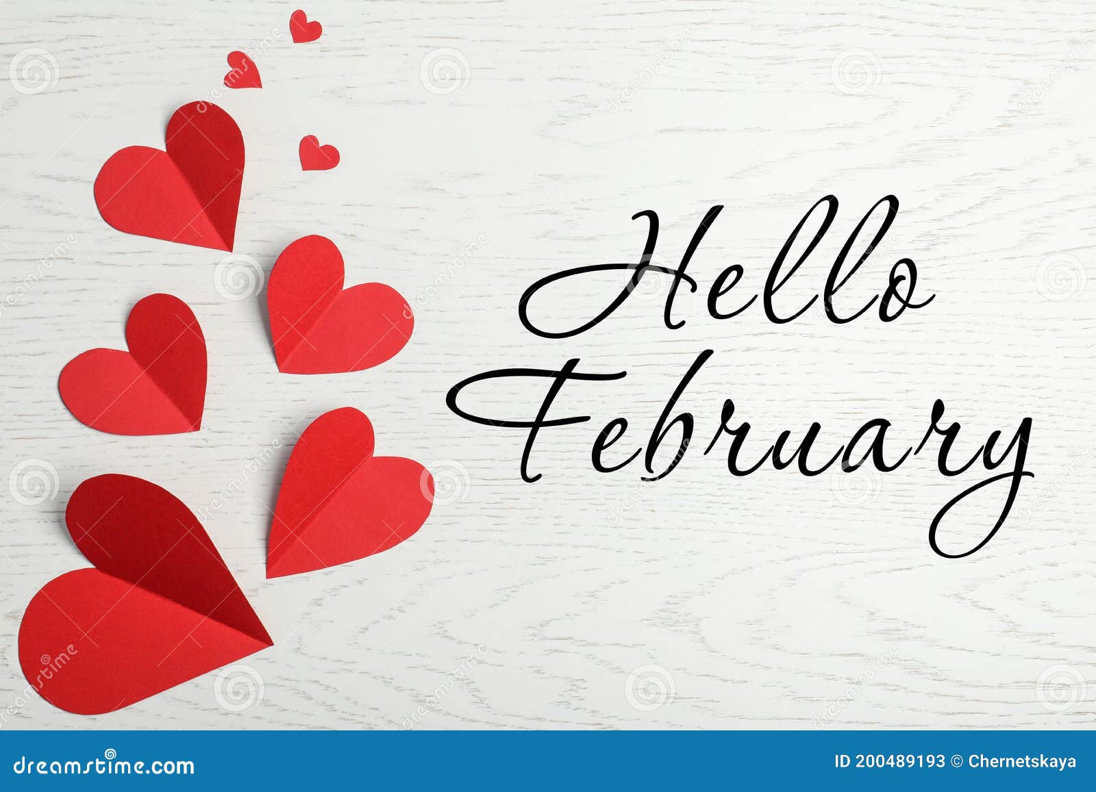 greeting card with text hello february. red paper hearts on white wooden background, flat lay