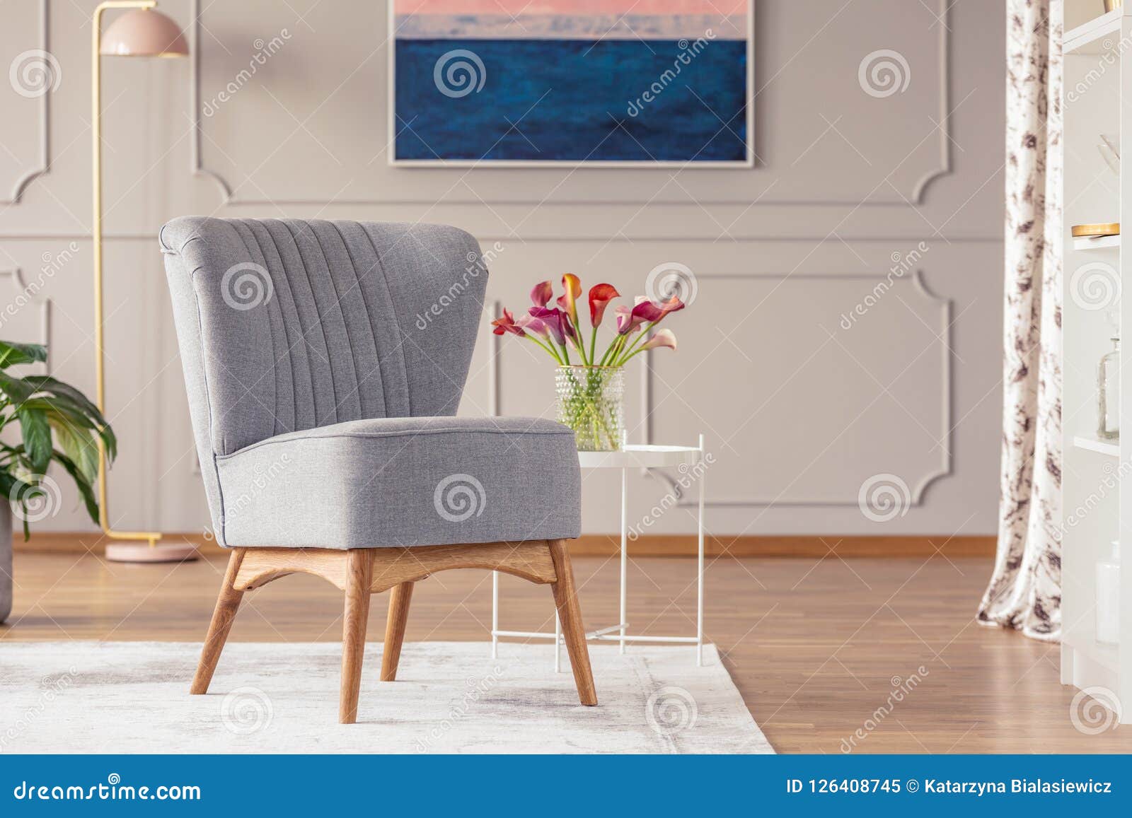 Grey Chair on Carpet Next To Table with Flowers in Elegant Living Room