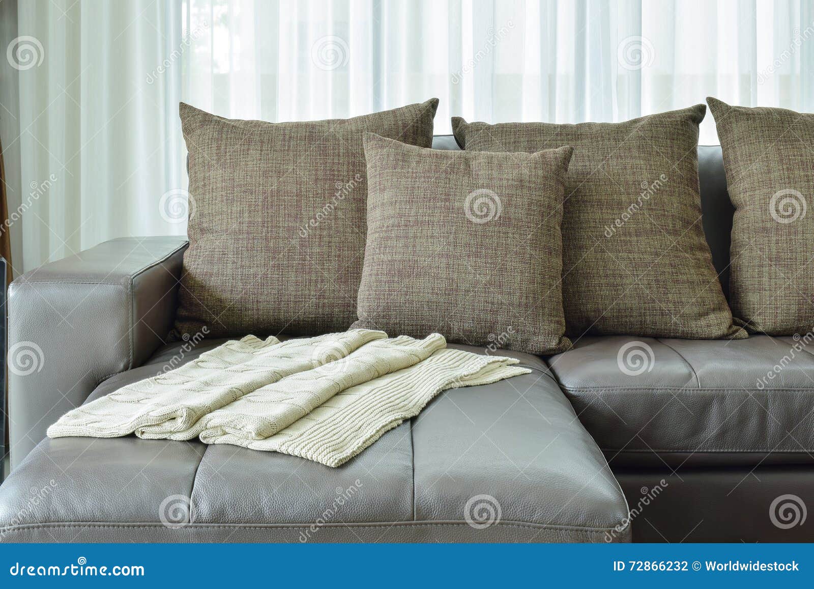Grey Leather Sofa with Texture Brown Pillows in Living Room Stock Photo