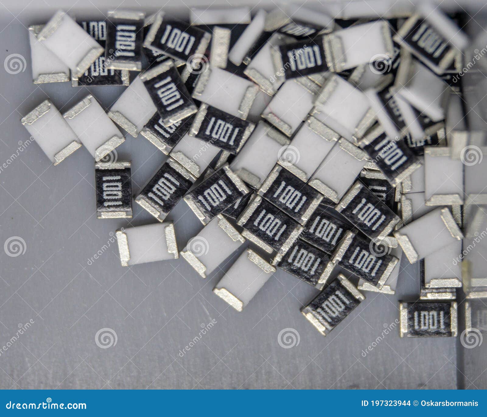 grey scattered microscopic smt surface mount chip resistors sorted in grey storage container