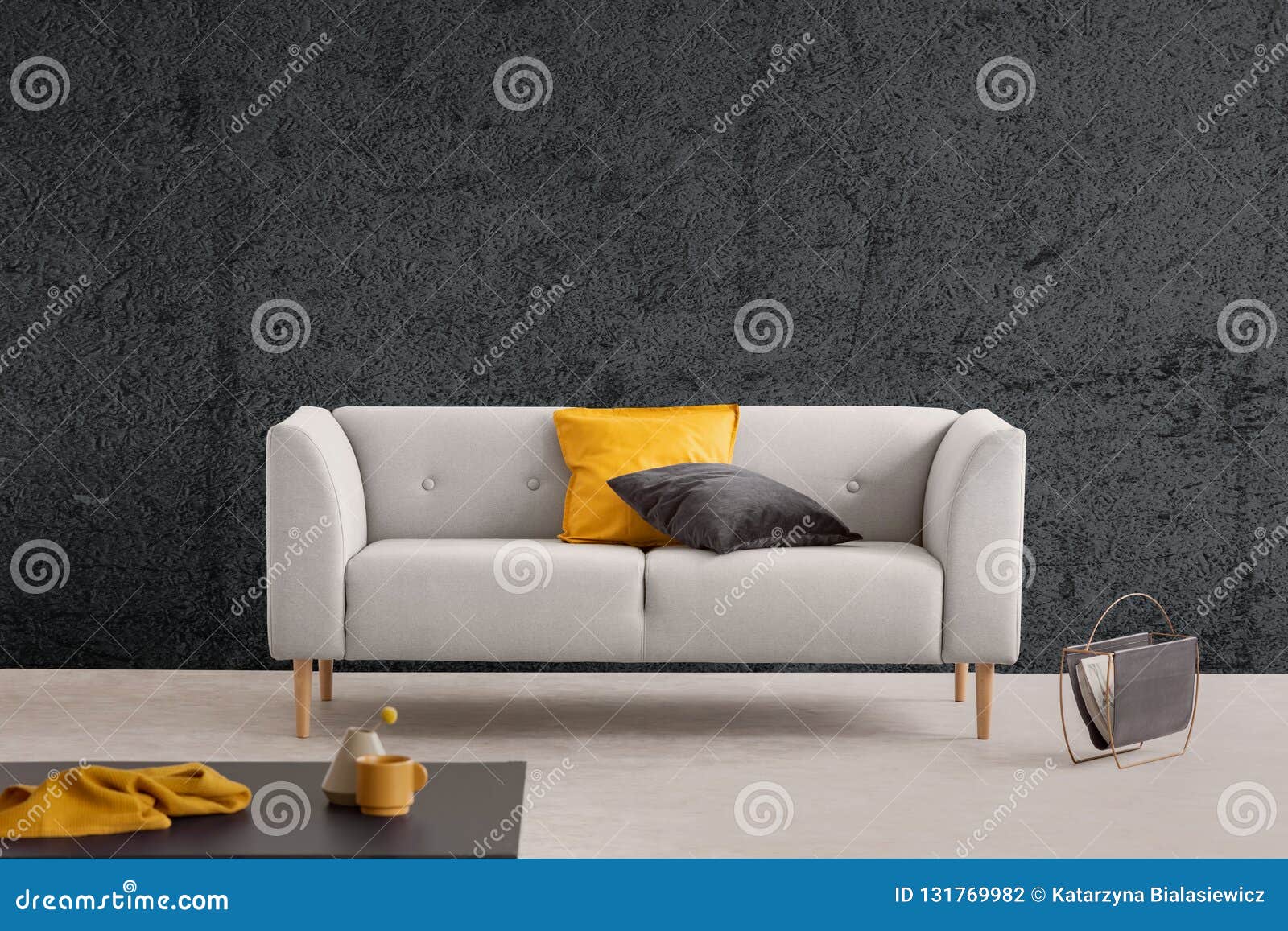 grey sofa in living room interior with textured wall and table. real photo