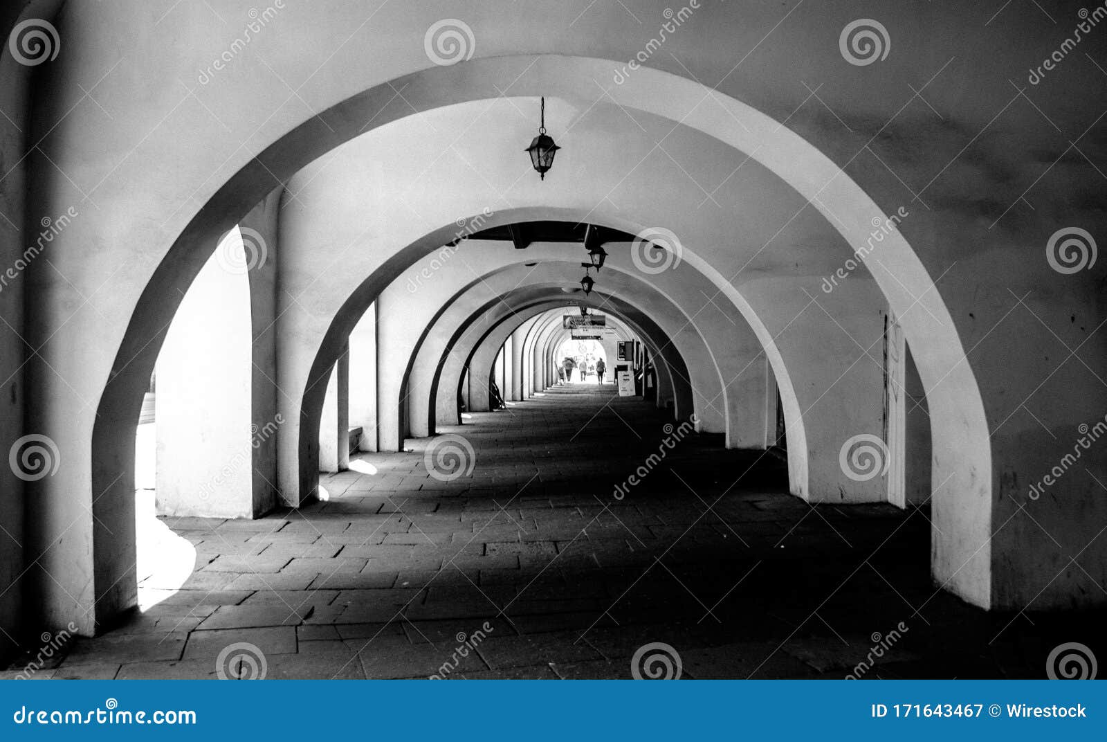 greyscale scenery of an outdoor tunnel in cracovia, polonia