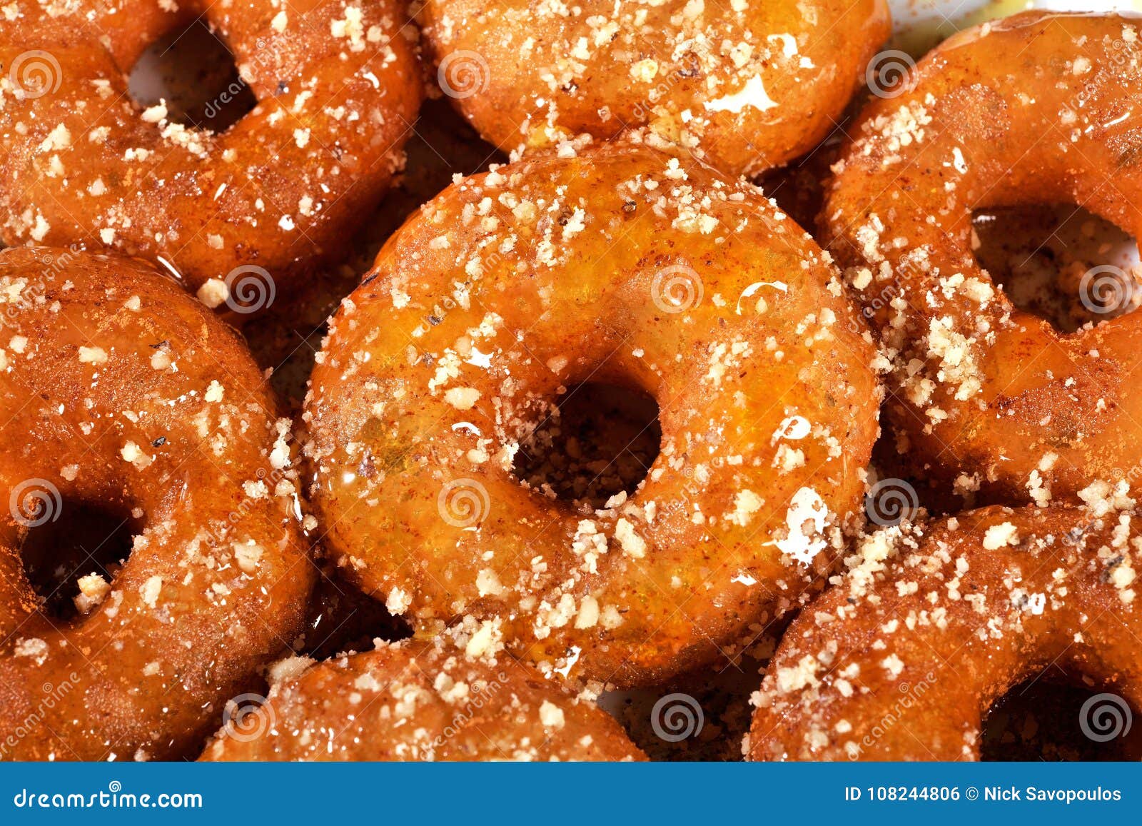 Griekse doughnut met stroop en honing loukoumades. Griekse donuts worden loukoumades traditioneel gediend doorweekt in hete die honingsstroop, met kaneel wordt en met gehakte okkernoten of geroosterde sesam wordt versierd bestrooid die