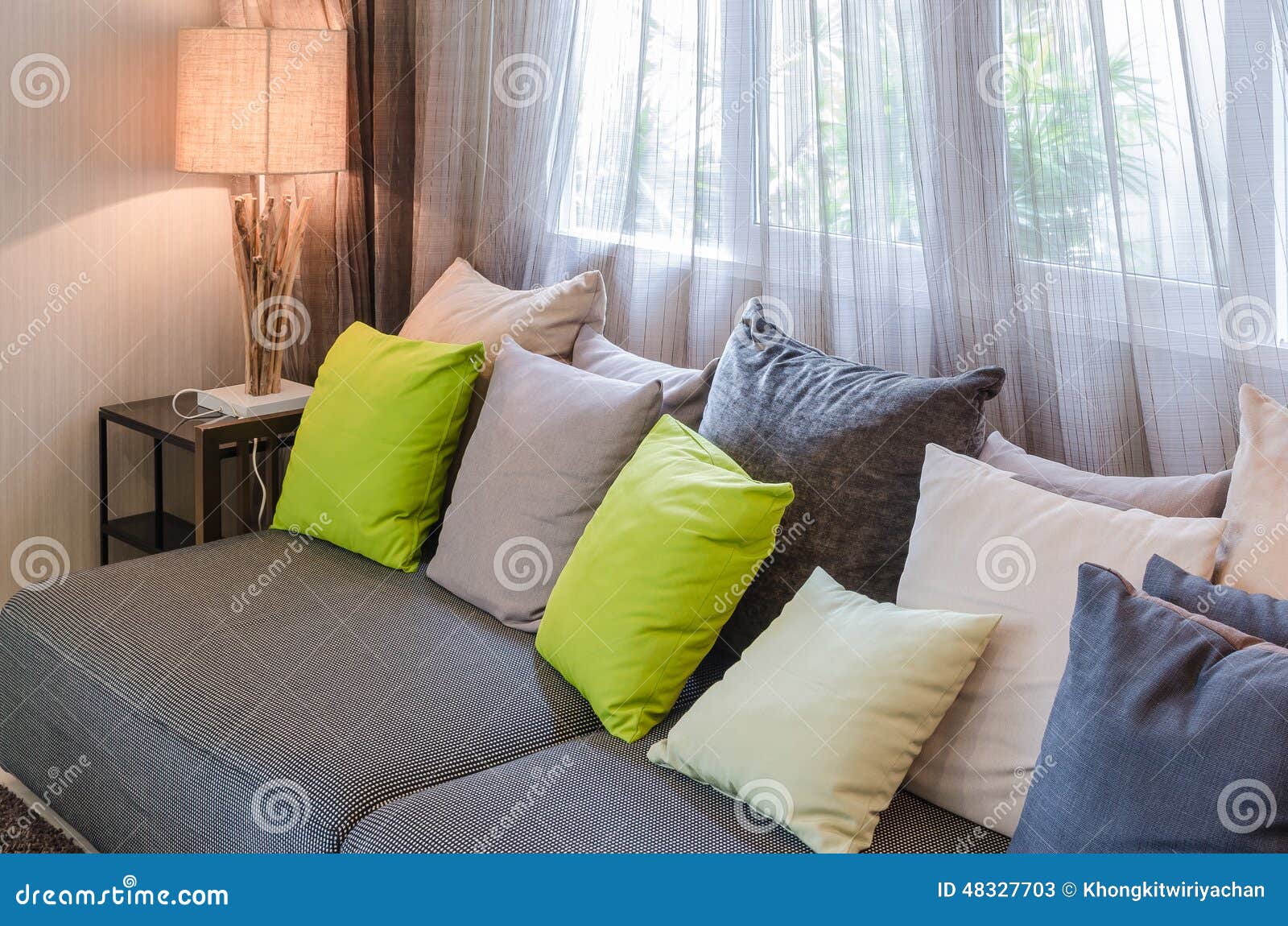 Grijze bank met groene hoofdkussens in woonkamer stock foto ...