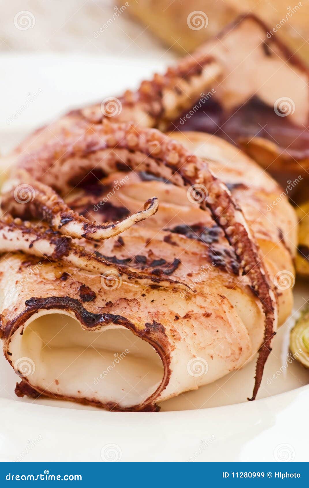 Grilled Calamari. Grilled cuttle fish with vegetable as closeup in a plate.