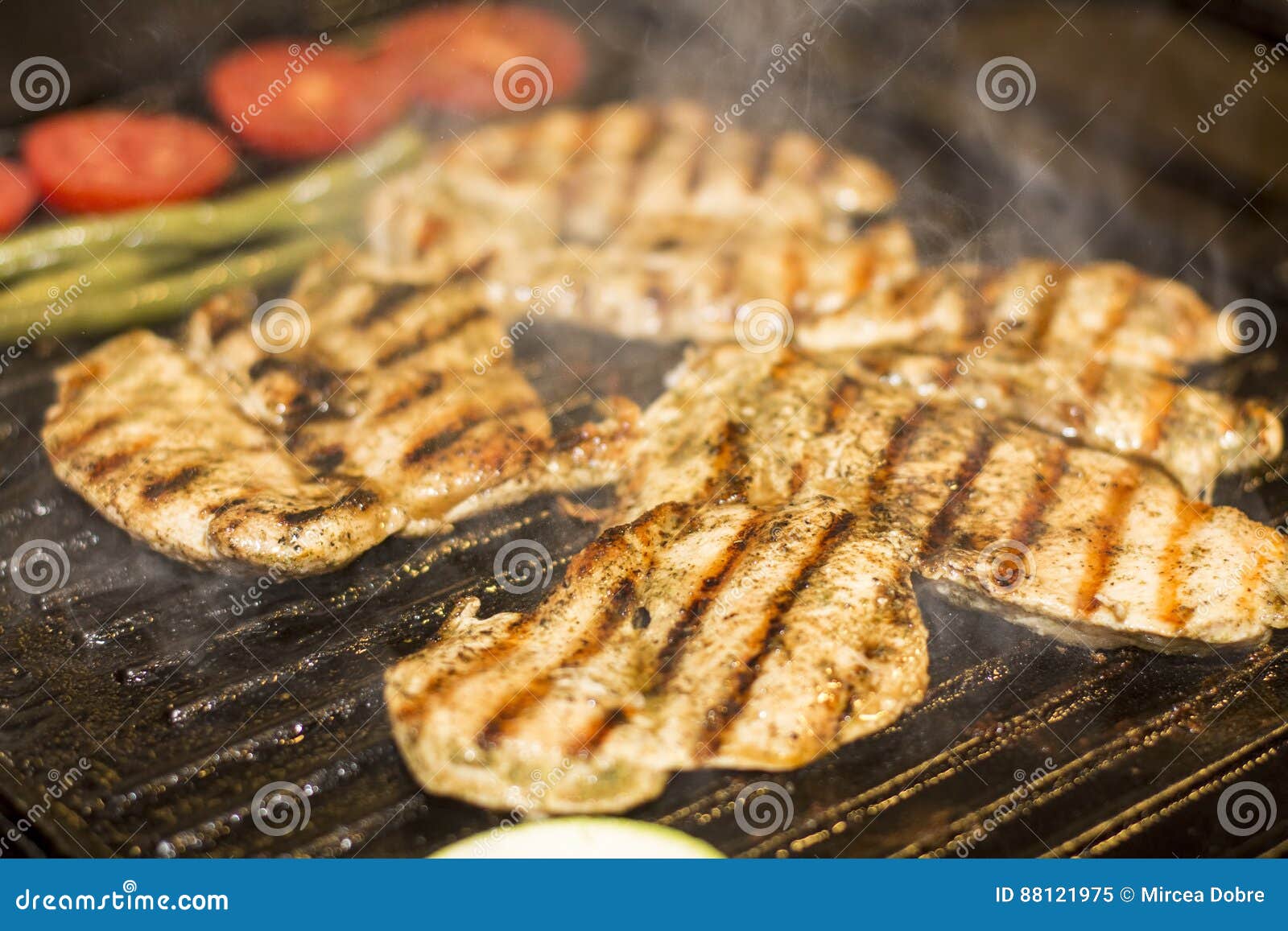 grilled chicken breast with sausage, fries and salad on grill
