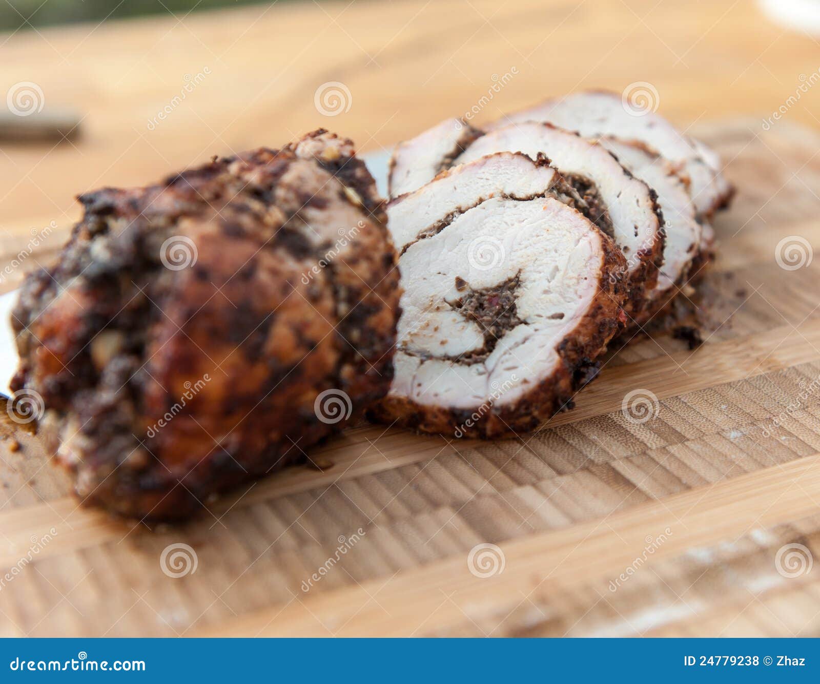 Grilled filled pork loin on a wood plate