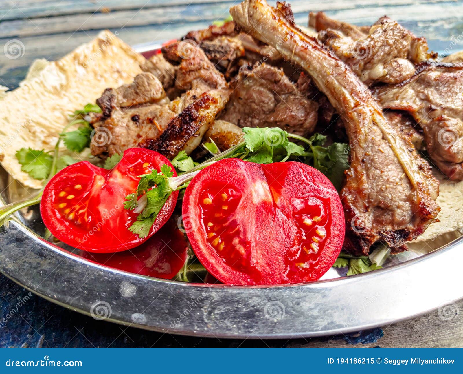 Grilled Lamb Loin with Tomatoes and Herbs is on a Platter Stock Image