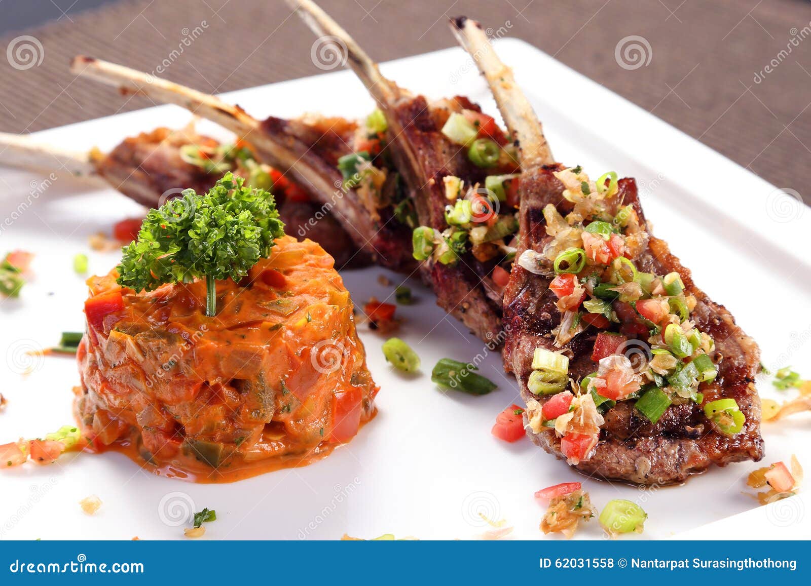 Grilled Lamb Ribs with Herbal Sauce on White Ceramic Tray Stock Photo