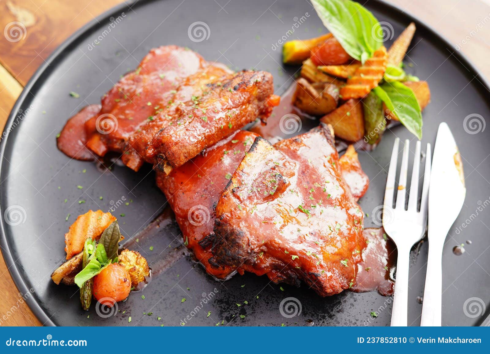 Grilled Pork Ribs and Side Dishes on a Black Plate Stock Photo Image