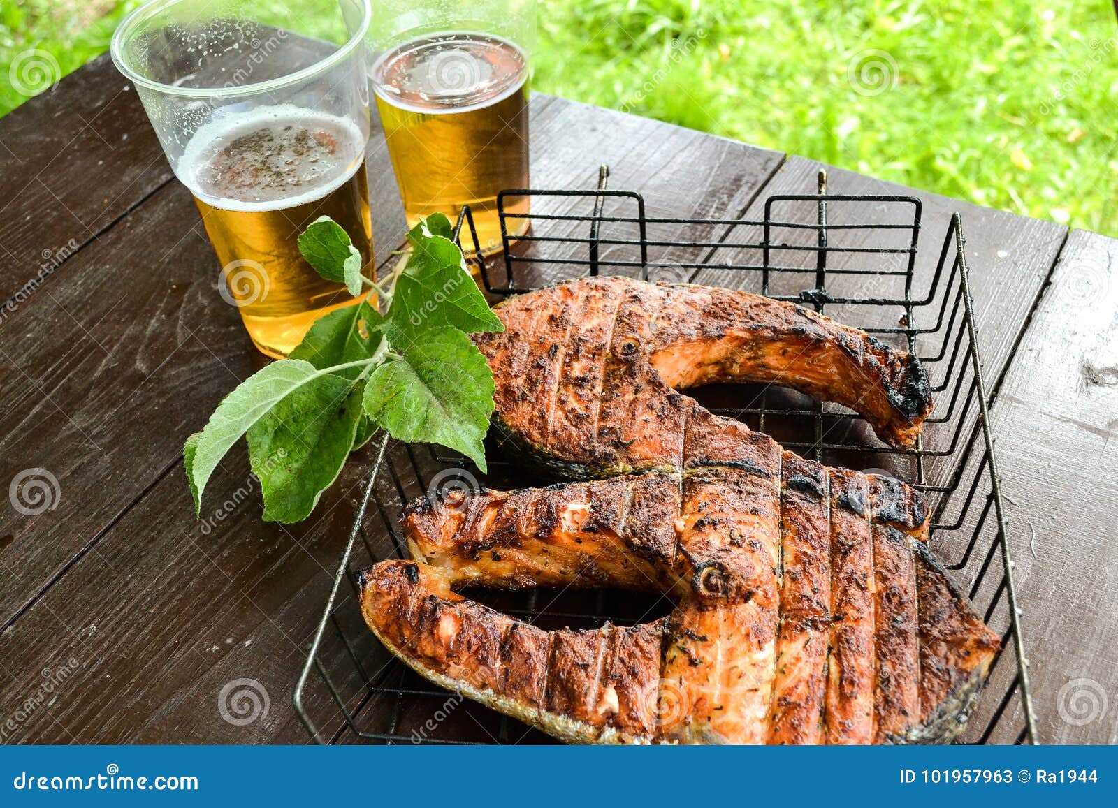 grilled salmon steak. two glasses with beer. picnic in nature