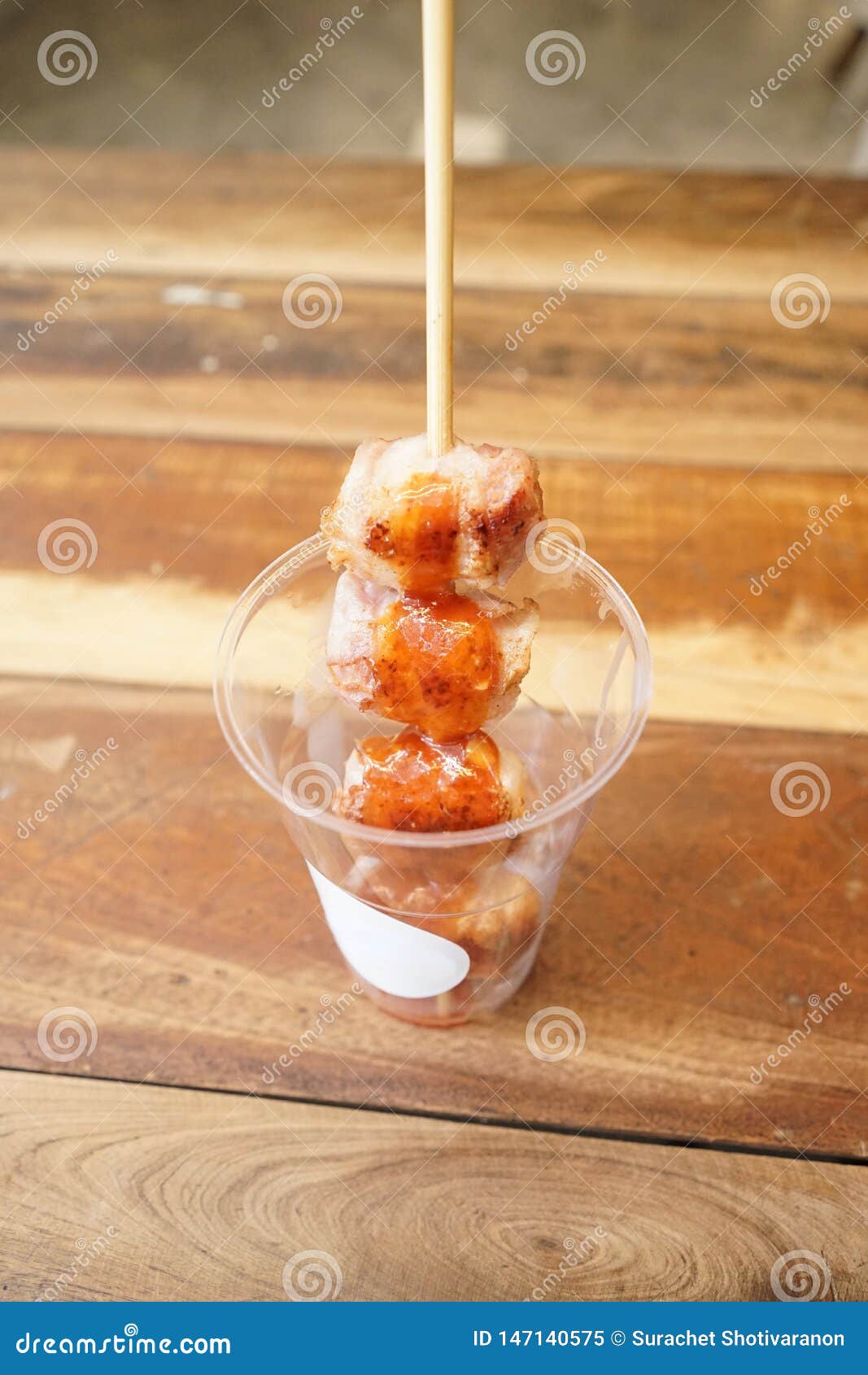 grilled sausage wrapped and rolled over with becon, dropping sweet chilli sauce. put it in plastic cup, ready to serve