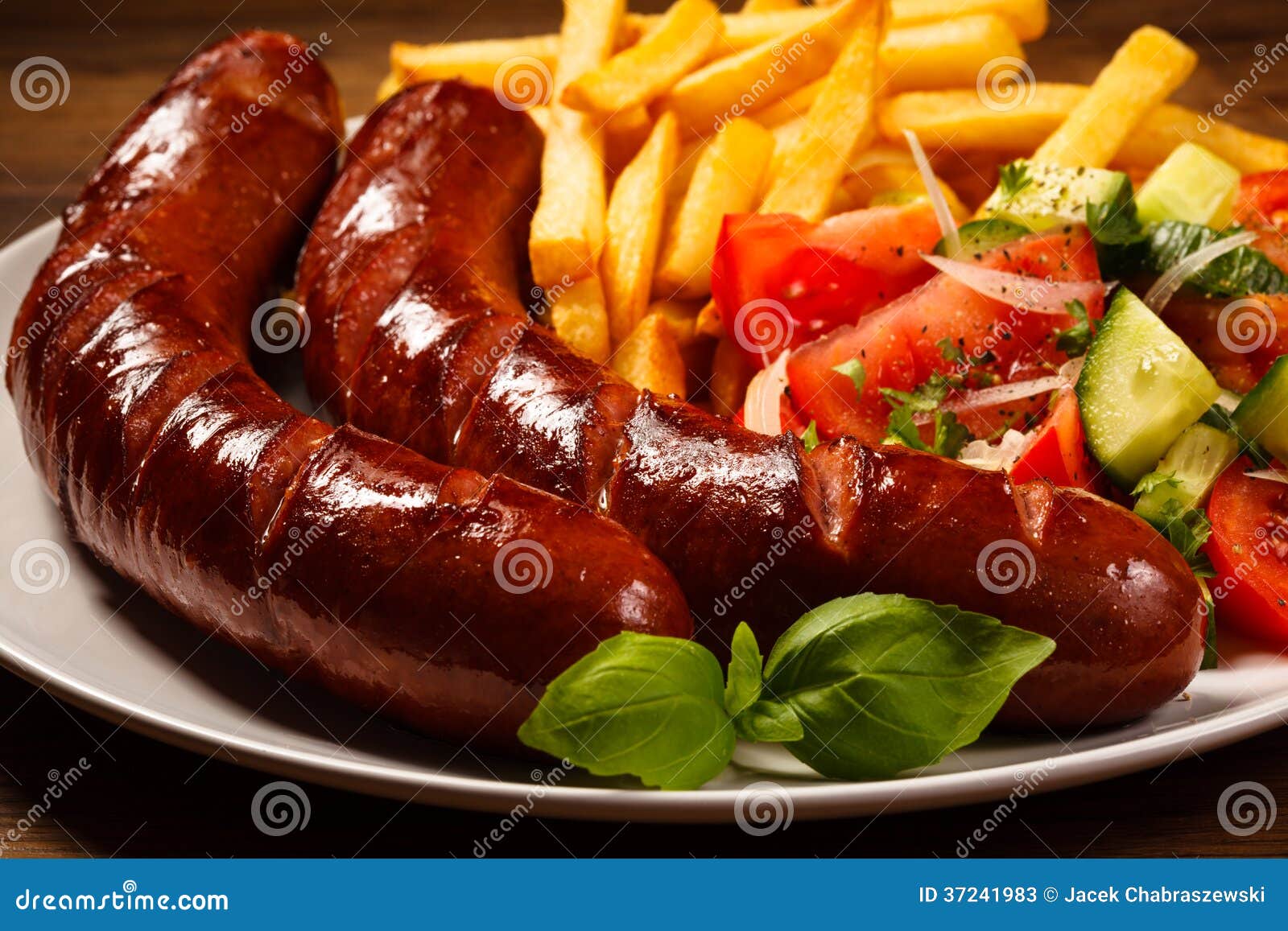 Grilled Sausages, Chips And Vegetable Salad Stock Photos
