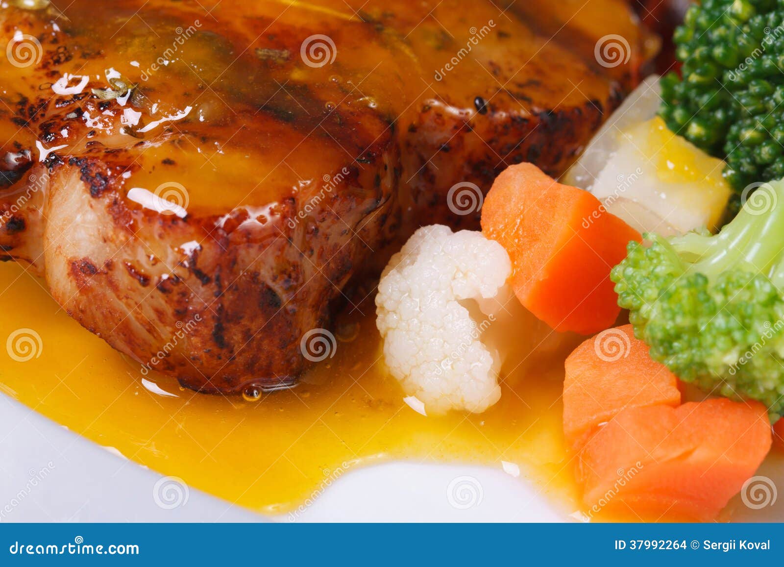 Grilled Steak with Sauce and Vegetable Garnish Macro Stock Photo