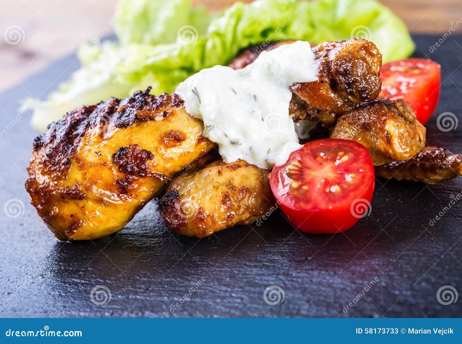 grilling. grilled chicken. grilled chicken legs. grilled chicken legs, lettuce and cherry tomatoes. traditional cuisine.