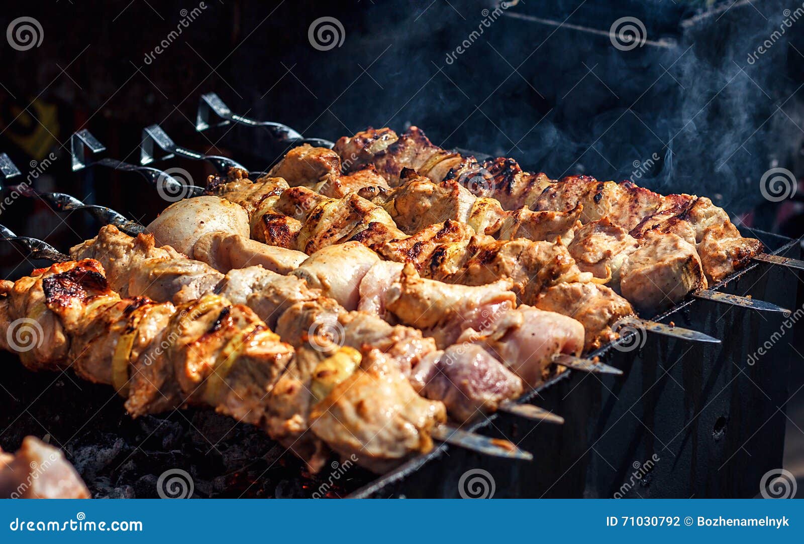 Grilling marinated shashlik on a grill. Shashlik is a form of Shish kebab  popular in Eastern, Central Europe and other places. Shashlyk (meaning  skewered meat) was originally made of lamb. Stock Photo