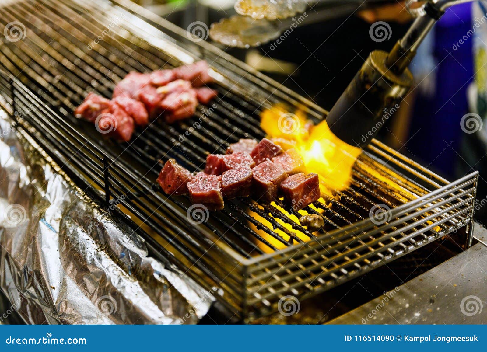 Grilling Slice of Meat on the Stove with Flame from Gas Pipe Selective