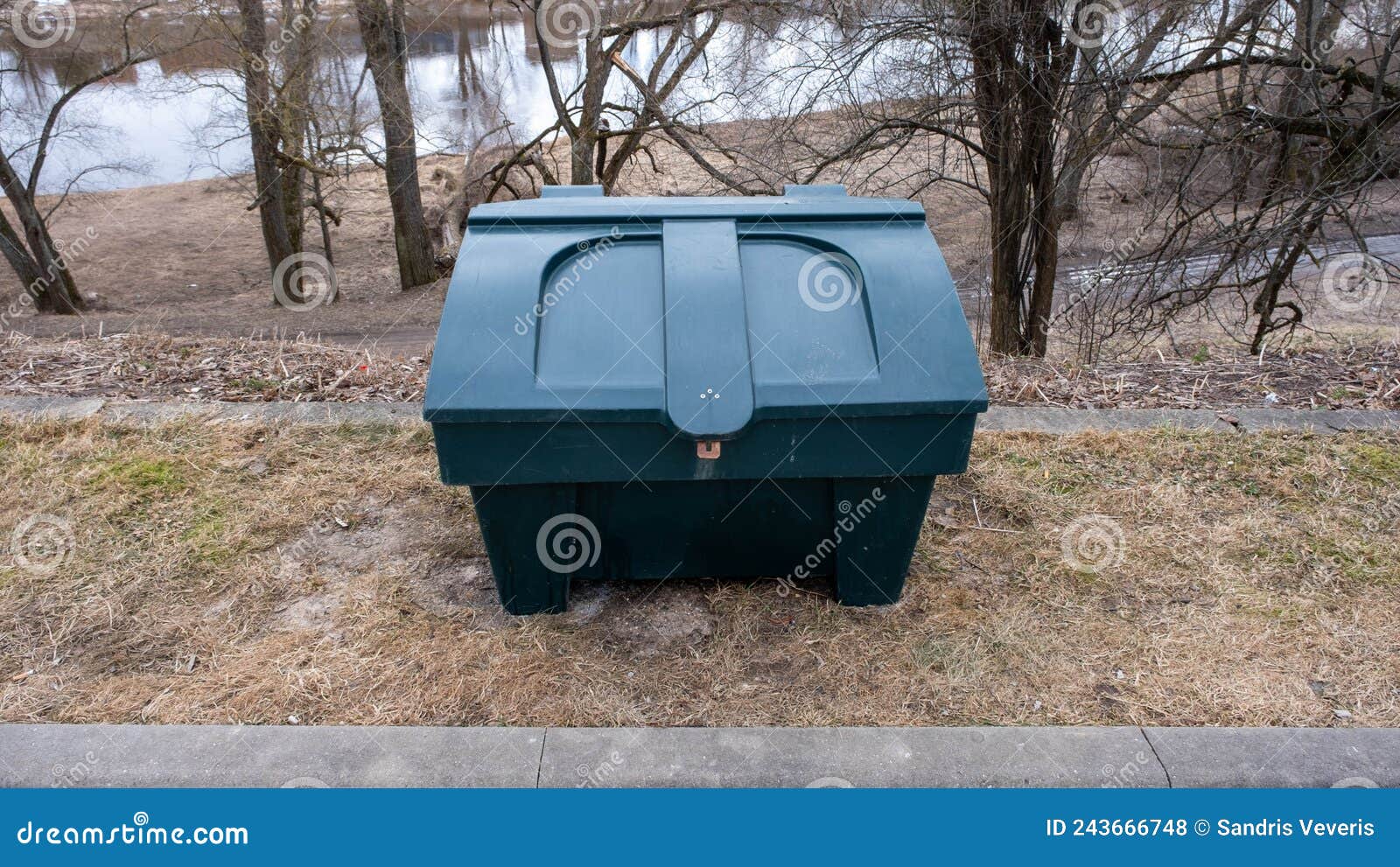 grit bin stand near outdoor concreat stair, sand for improve traction on snowy and icy steps during winter season. green