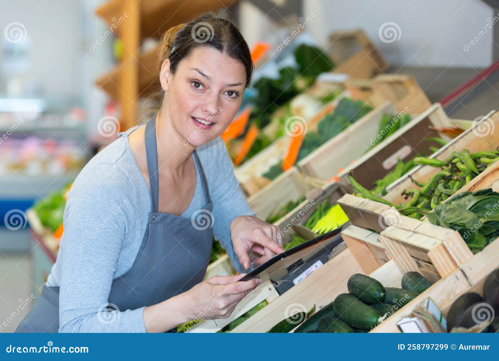 Grocery Store Worker with Surprised Expression Using Tablet Stock Image