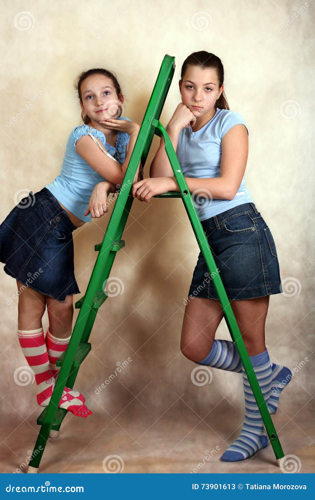 Groene trapladder. Portret van de jonge meisjes met trapladder op een gele achtergrond