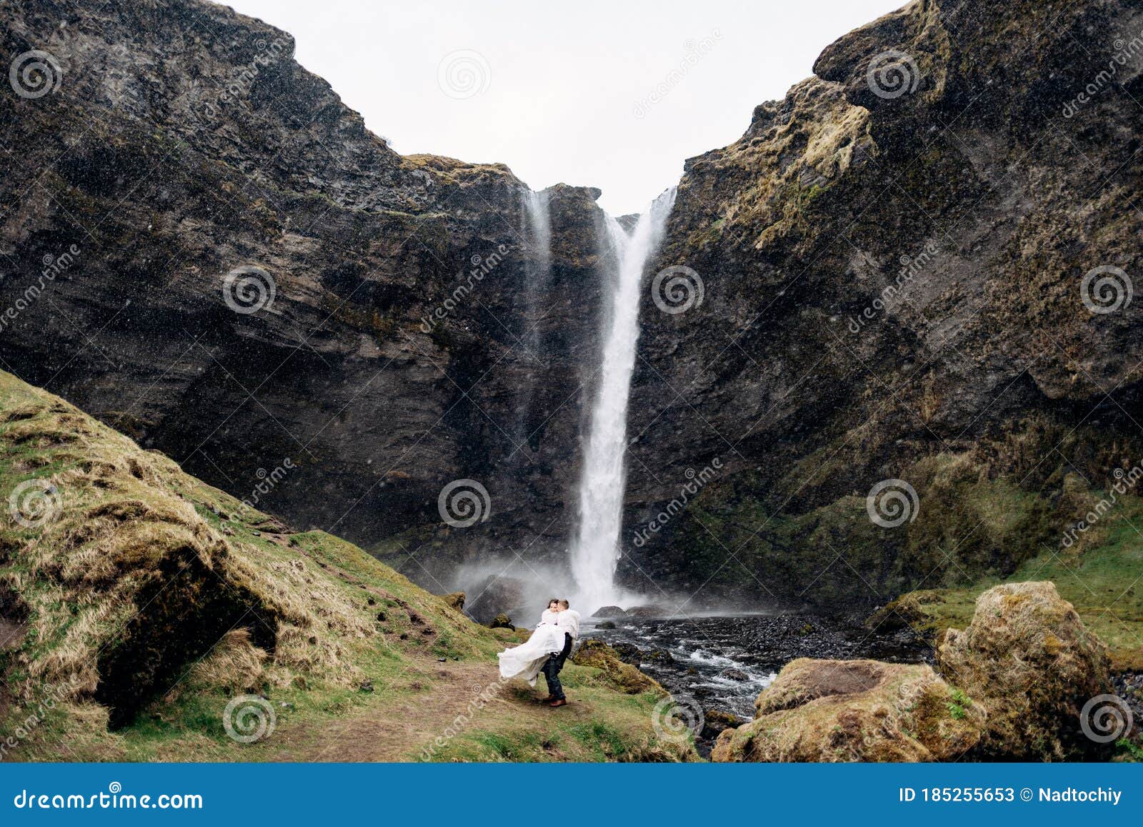 The Groom Circles The Bride In His Arms Near The Waterfall It Is Snowing Destination Iceland Wedding Near Kvernufoss Stock Image Image Of Rock Elopement
