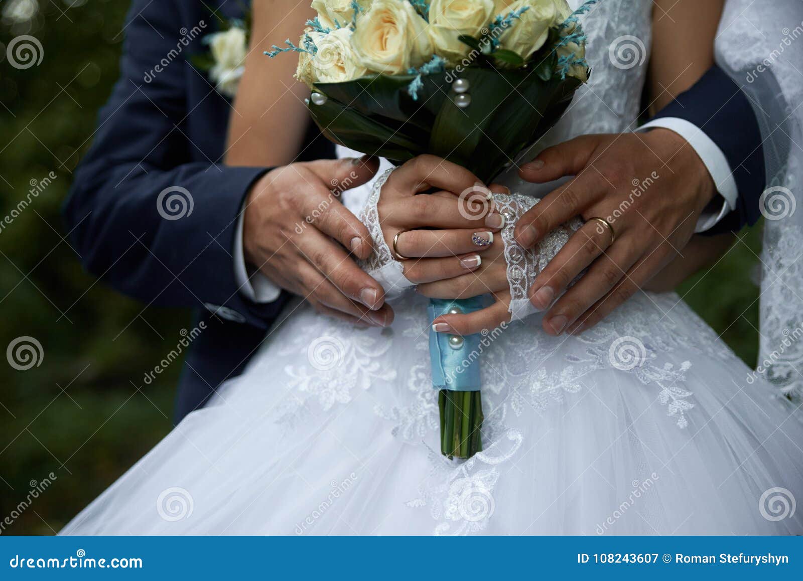 Groom Hugging Bride in White Dress from Behind Bouquet Closeup Stock ...