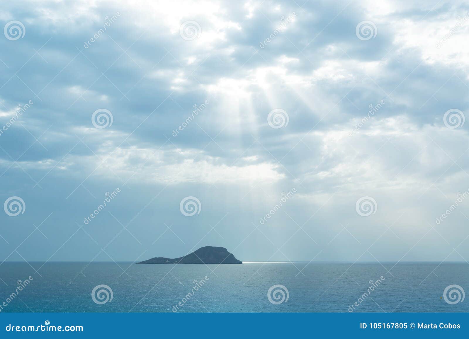 grosa island silhouette iluminated by sun ray through the clouds