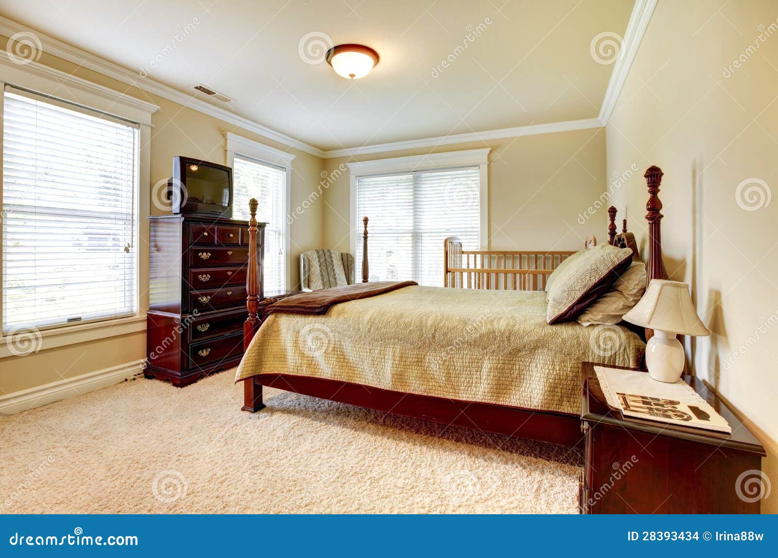 Grote heldere slaapkamer met houten meubilair en beige tonen ...