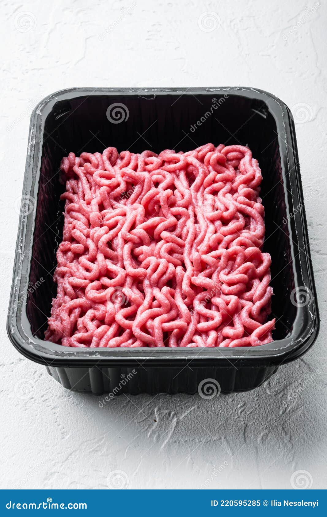 Ground Beef Meat in Plastic Tray, on White Stone Background Stock Image