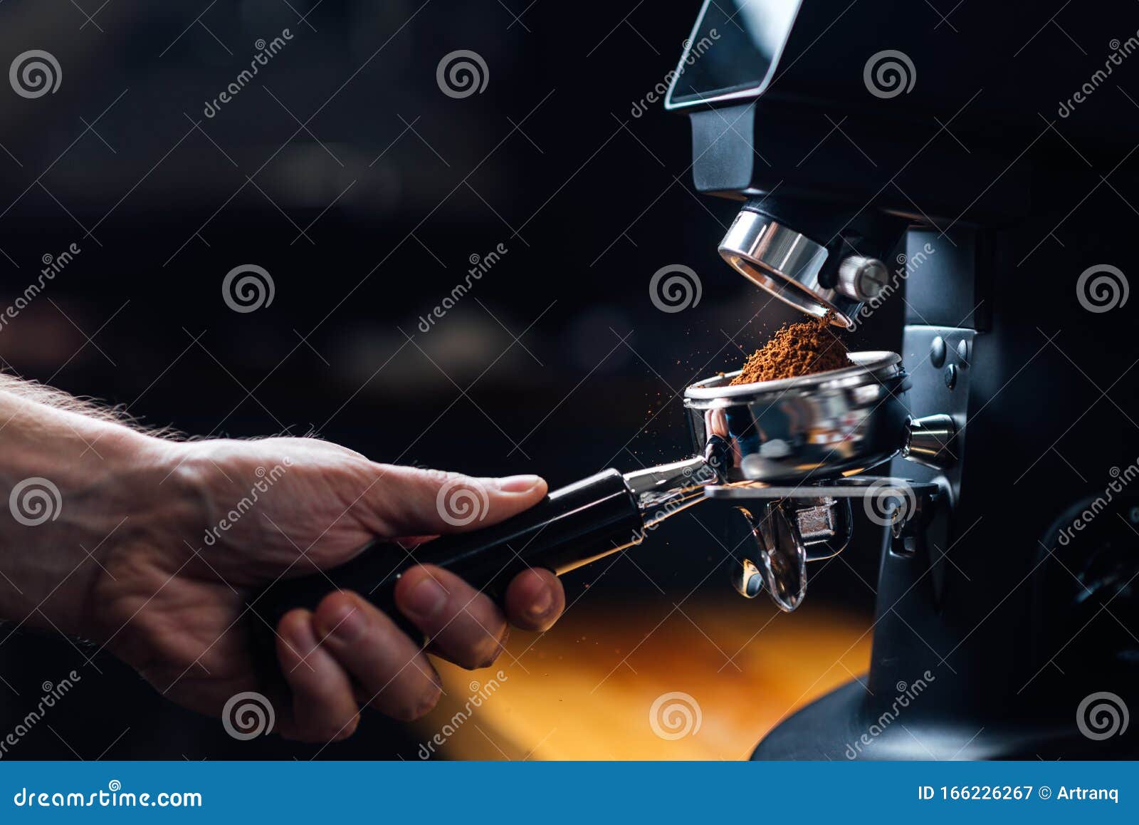 ground coffee pouring into a portafilter with a grinder