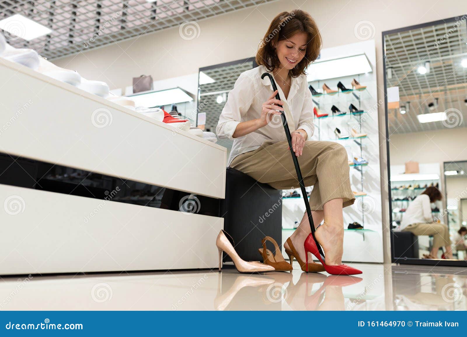 Ground View of Attractive Female Buying New Red Shoes. Stock Photo ...