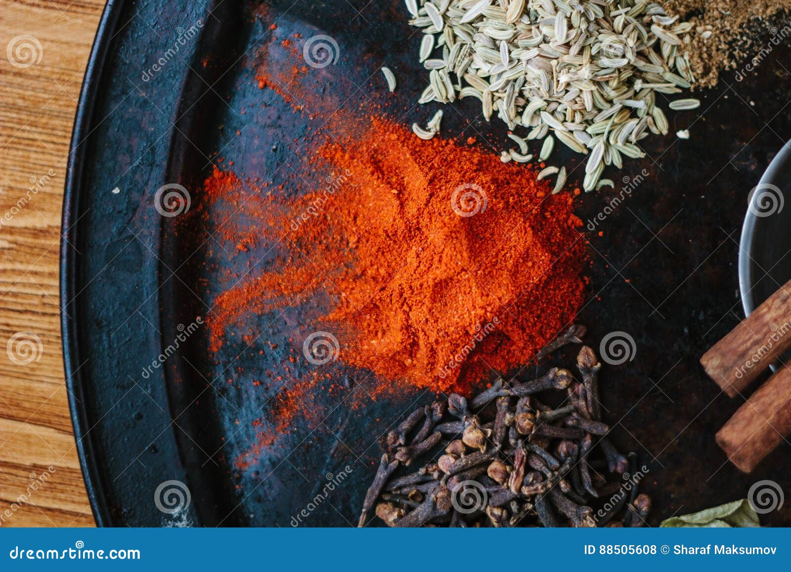 Grounded Chili Pepper on Black Rustic Surface, Surrounded by Spices