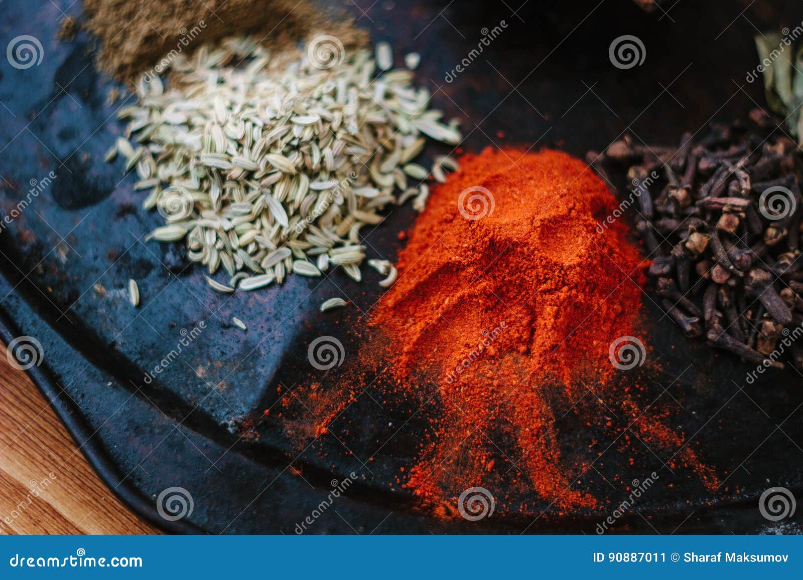 Grounded Chili Pepper on Black Rustic Surface, Surrounded by Spices