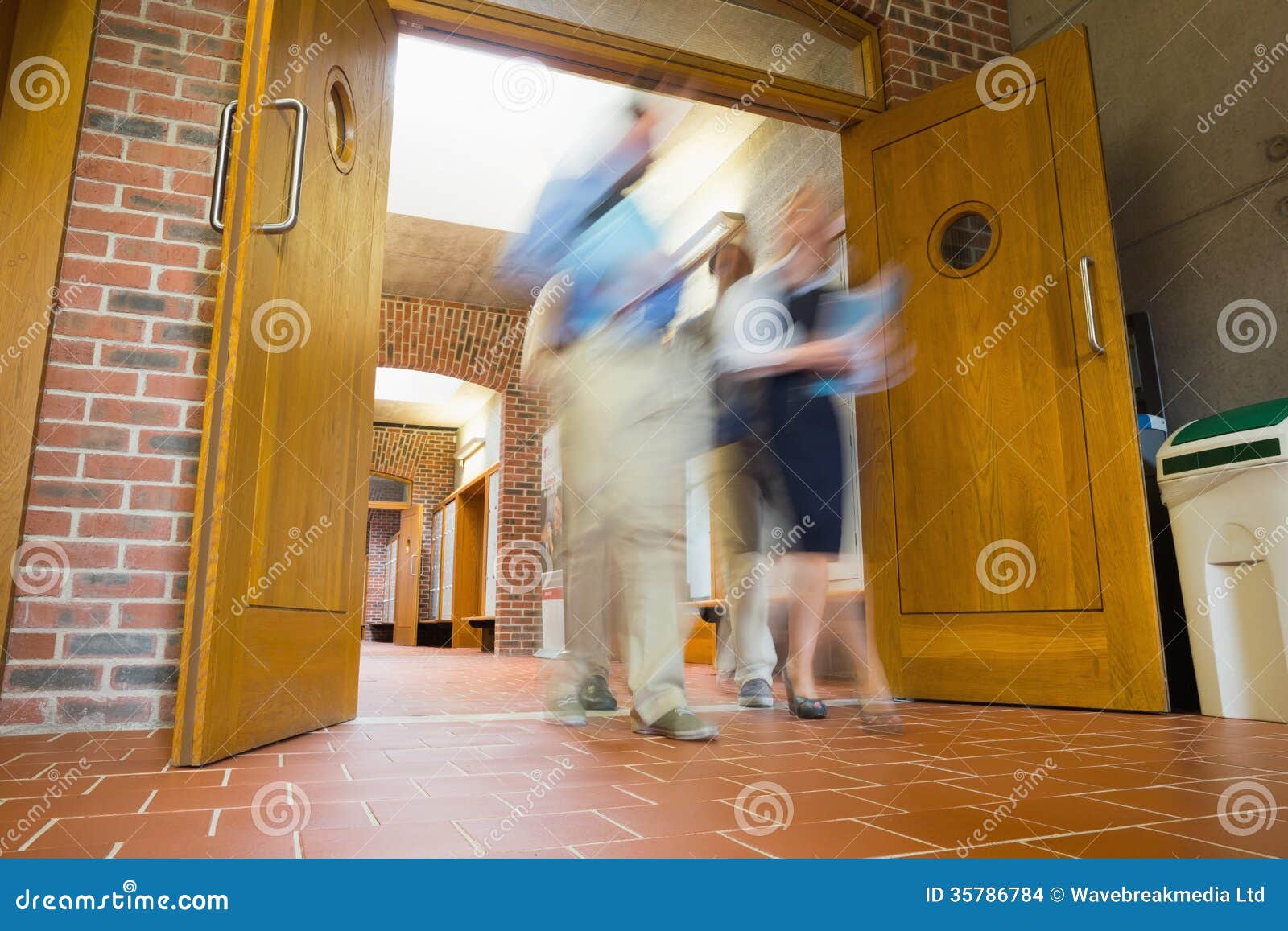 Group of Blurred People Walking through Open Doors Stock Photo Image