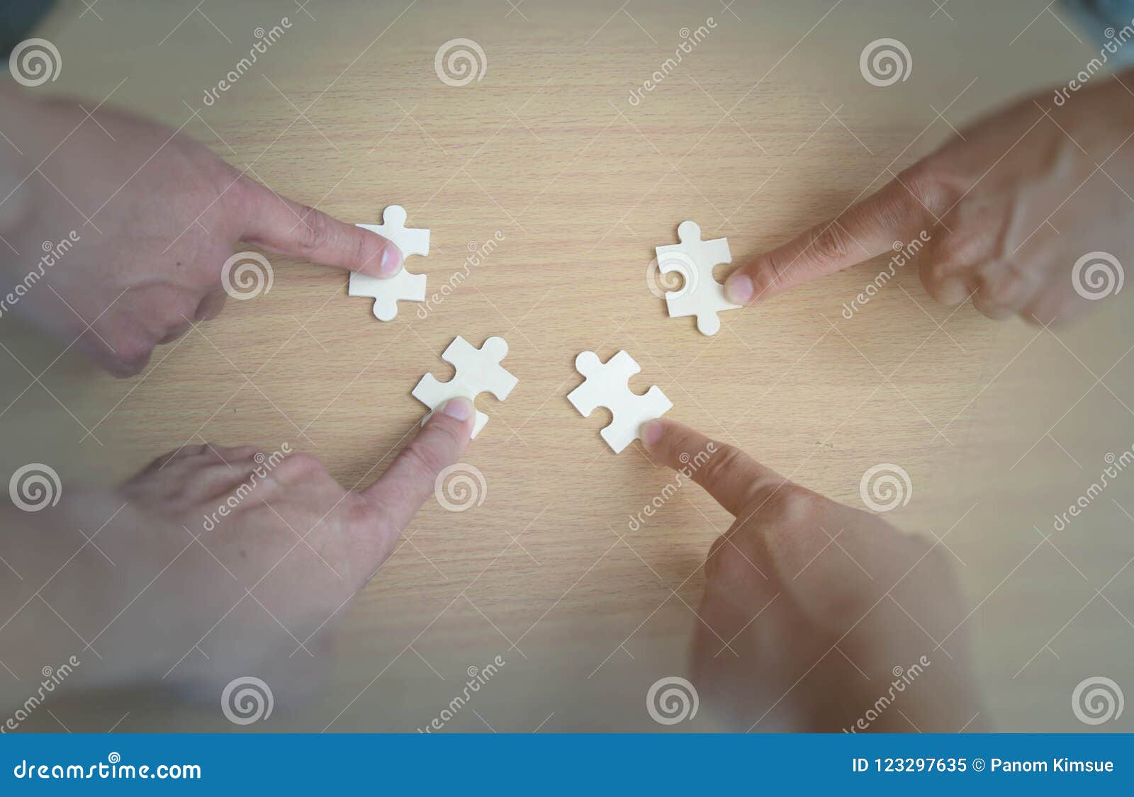 group of business people assembling jigsaw puzzle wanting to put pieces of puzzle together on wood table backgroung for help suppo