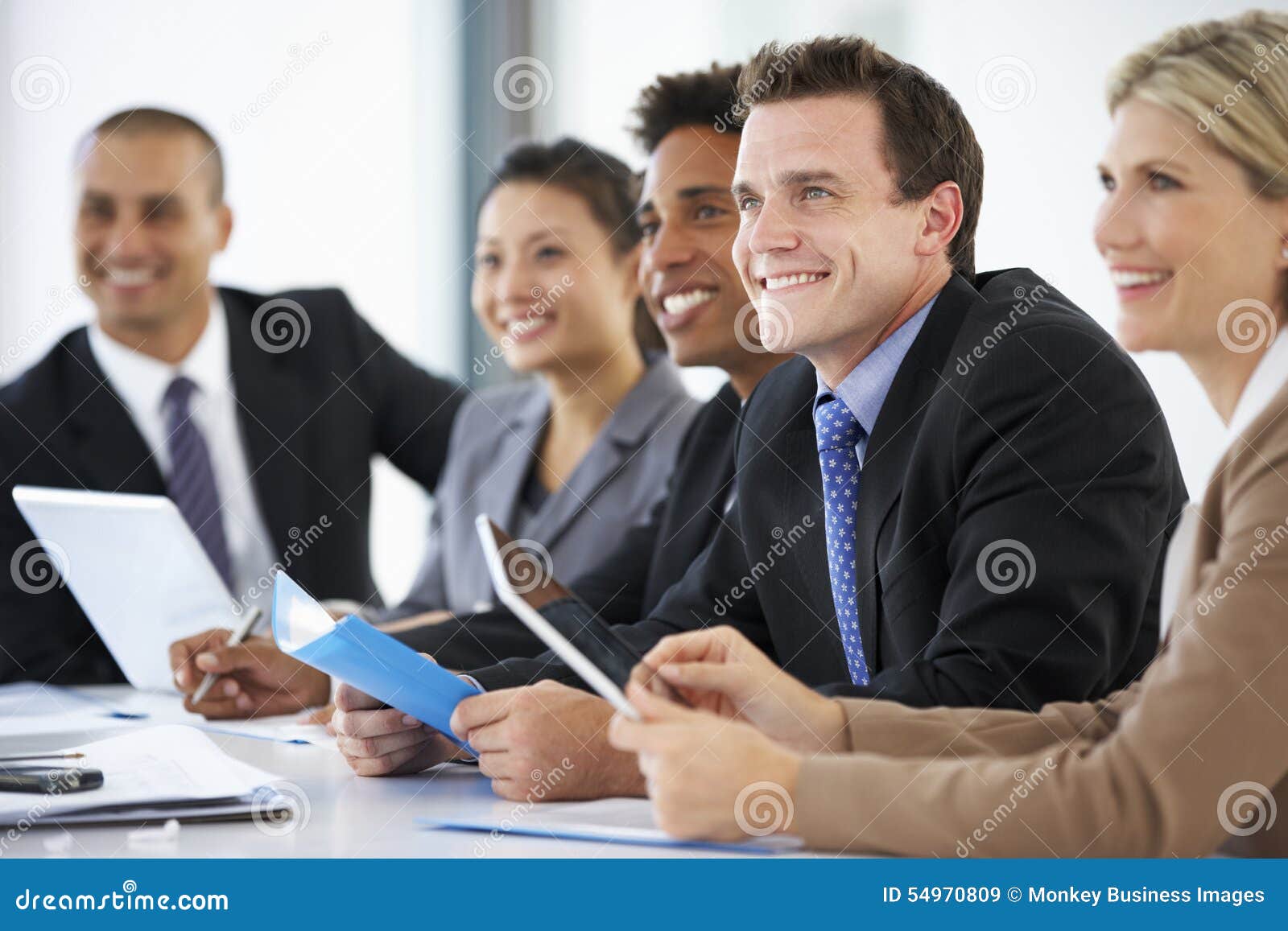 group of business people listening to colleague addressing office meeting