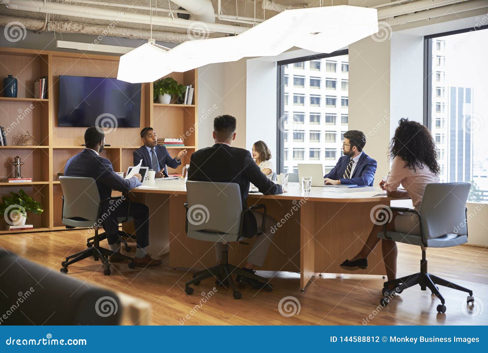 Group of Business Professionals Meeting Around Table in Modern Office
