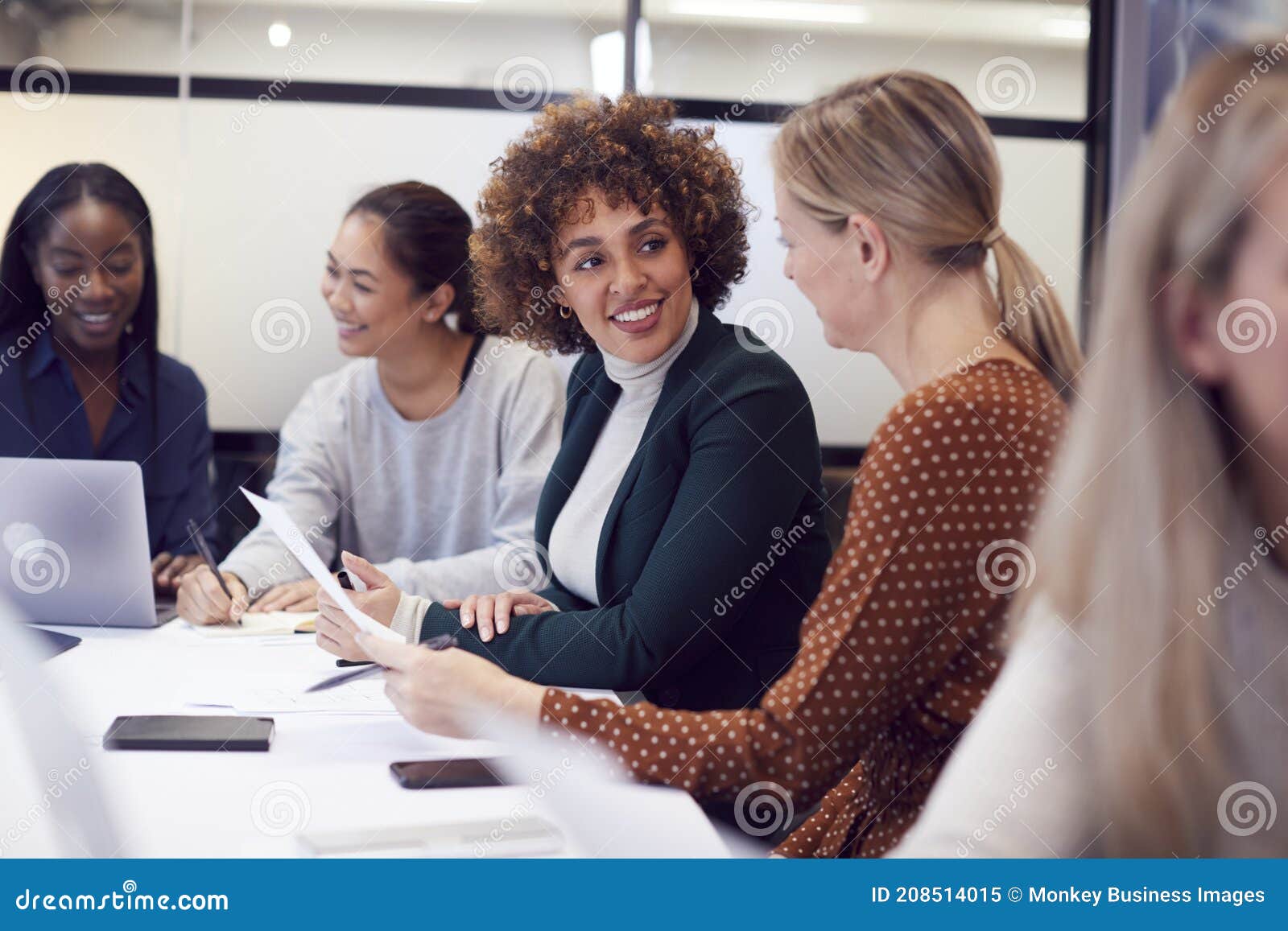 group of businesswomen collaborating in creative meeting around table in modern office