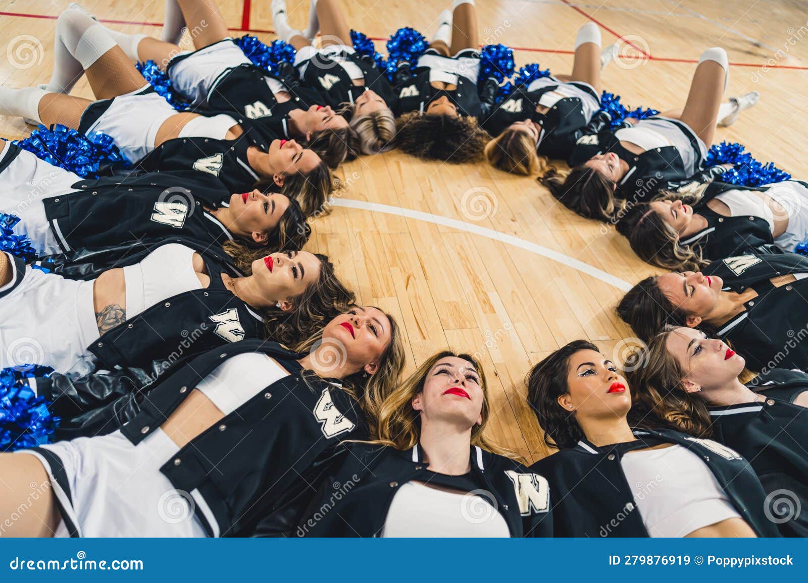 A Group of Cheerleaders Lying on the Floor Forming a Circle with Their ...