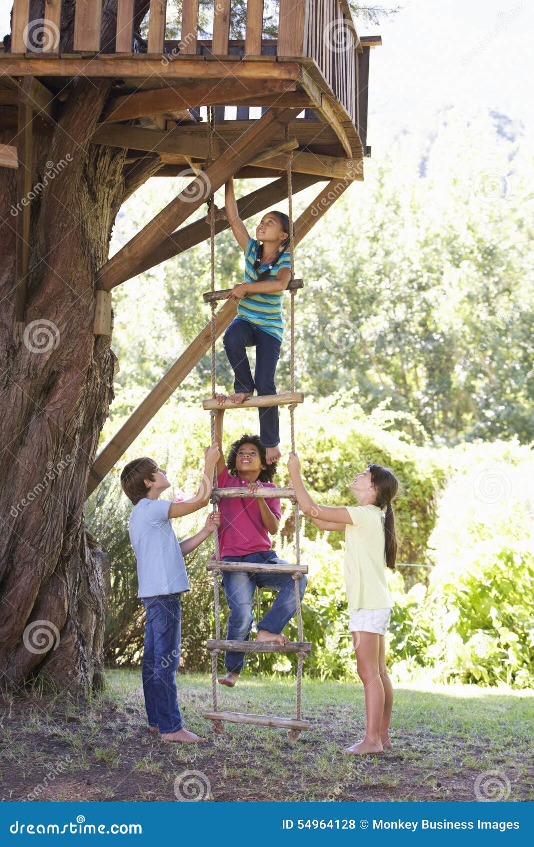 group of children climbing rope ladder to treehouse