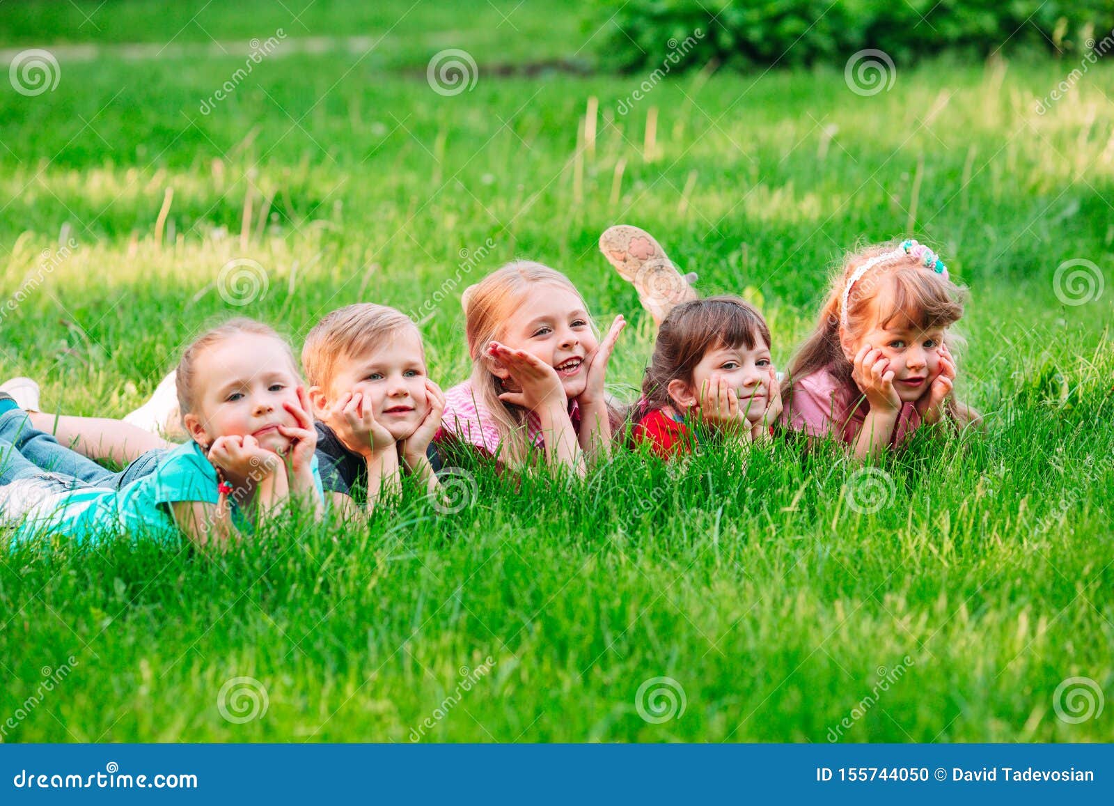 A Group of Children Lying on the Green Grass in the Park. the ...