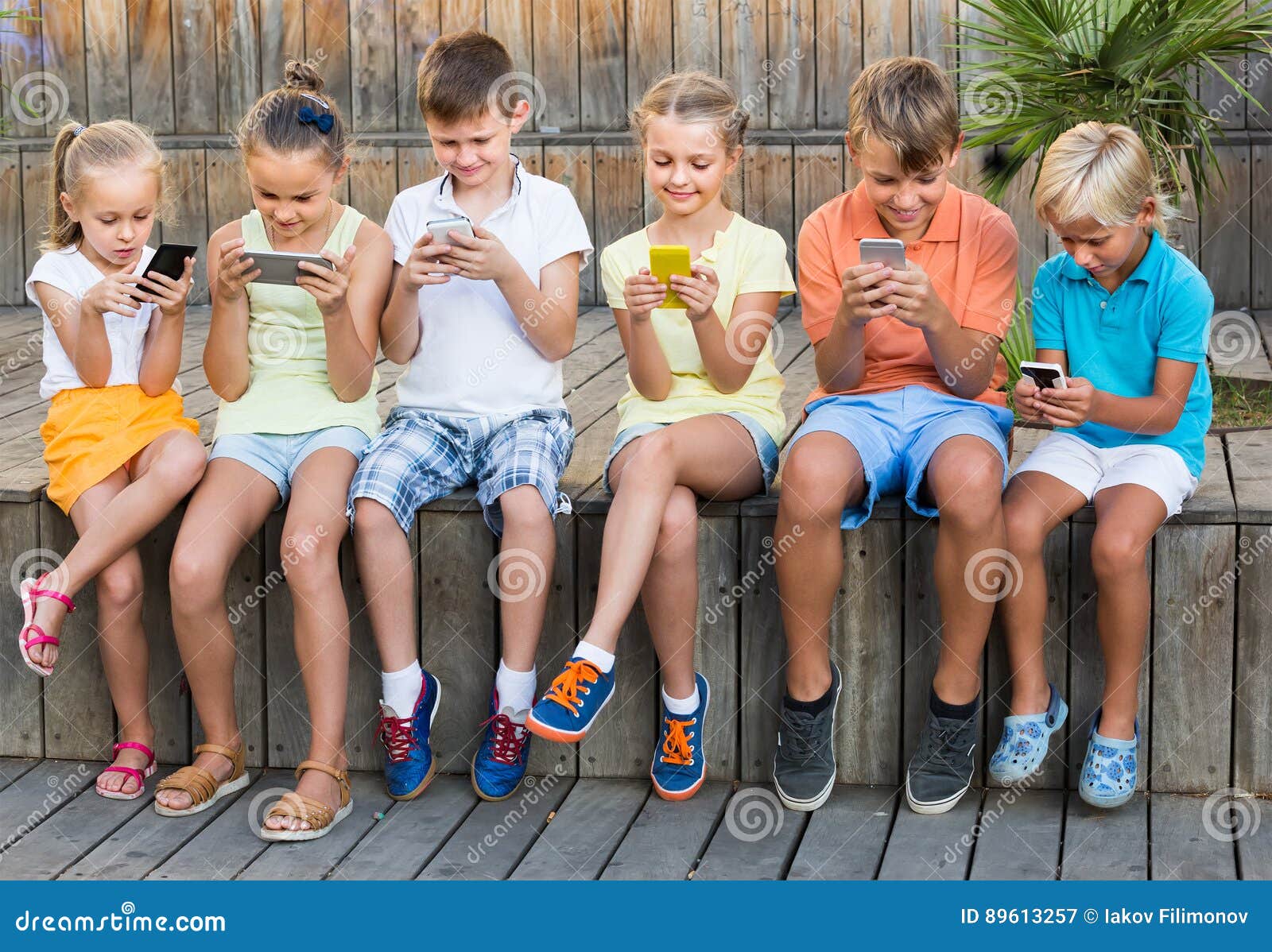 Group Of Young Asian People Sitting And Addicted To Playing Mobile