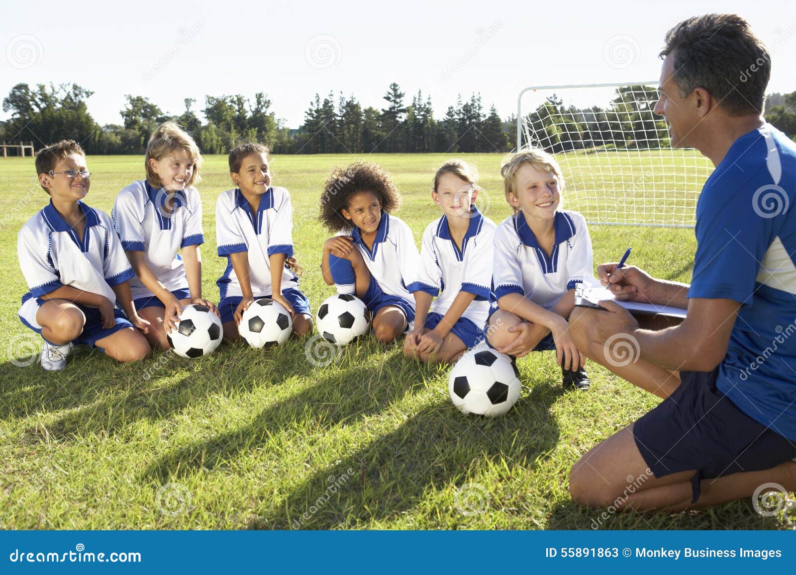Group of Children in Soccer Team Having Training with Coach Stock Image