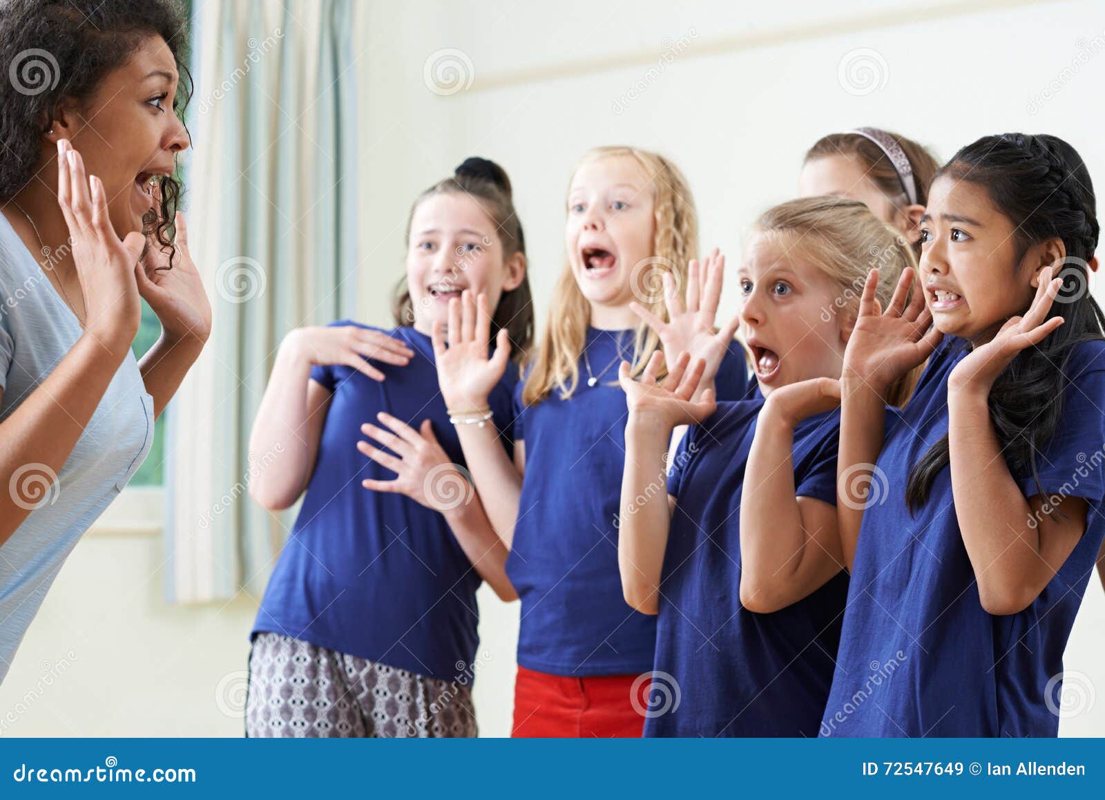 group of children with teacher enjoying drama class together