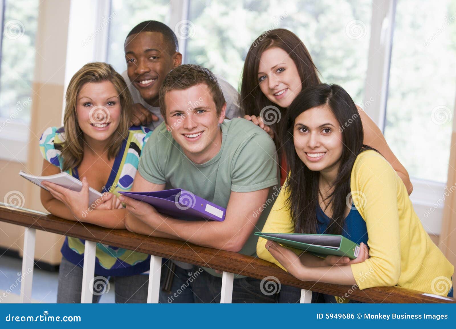 group of college students leaning on banister